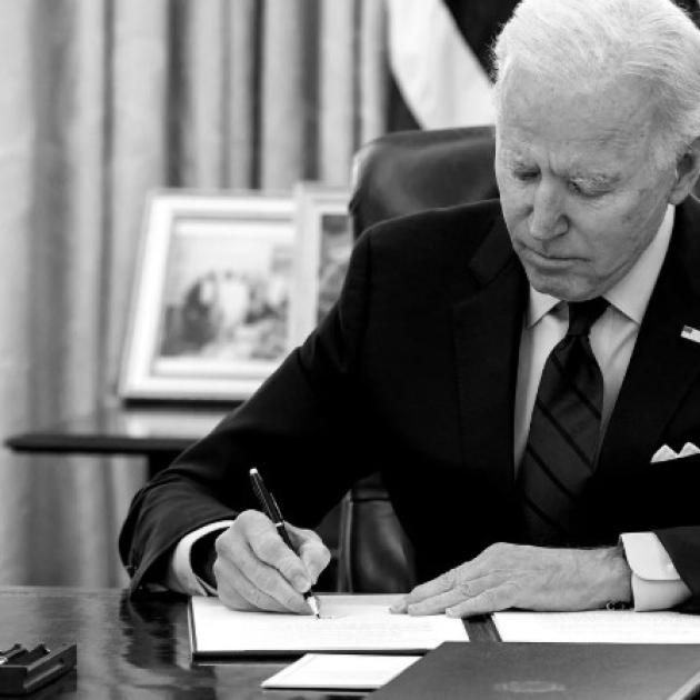 Biden at his desk signing something