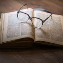 Open book with glasses lying on it