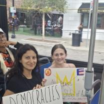Young women with signs on a bus